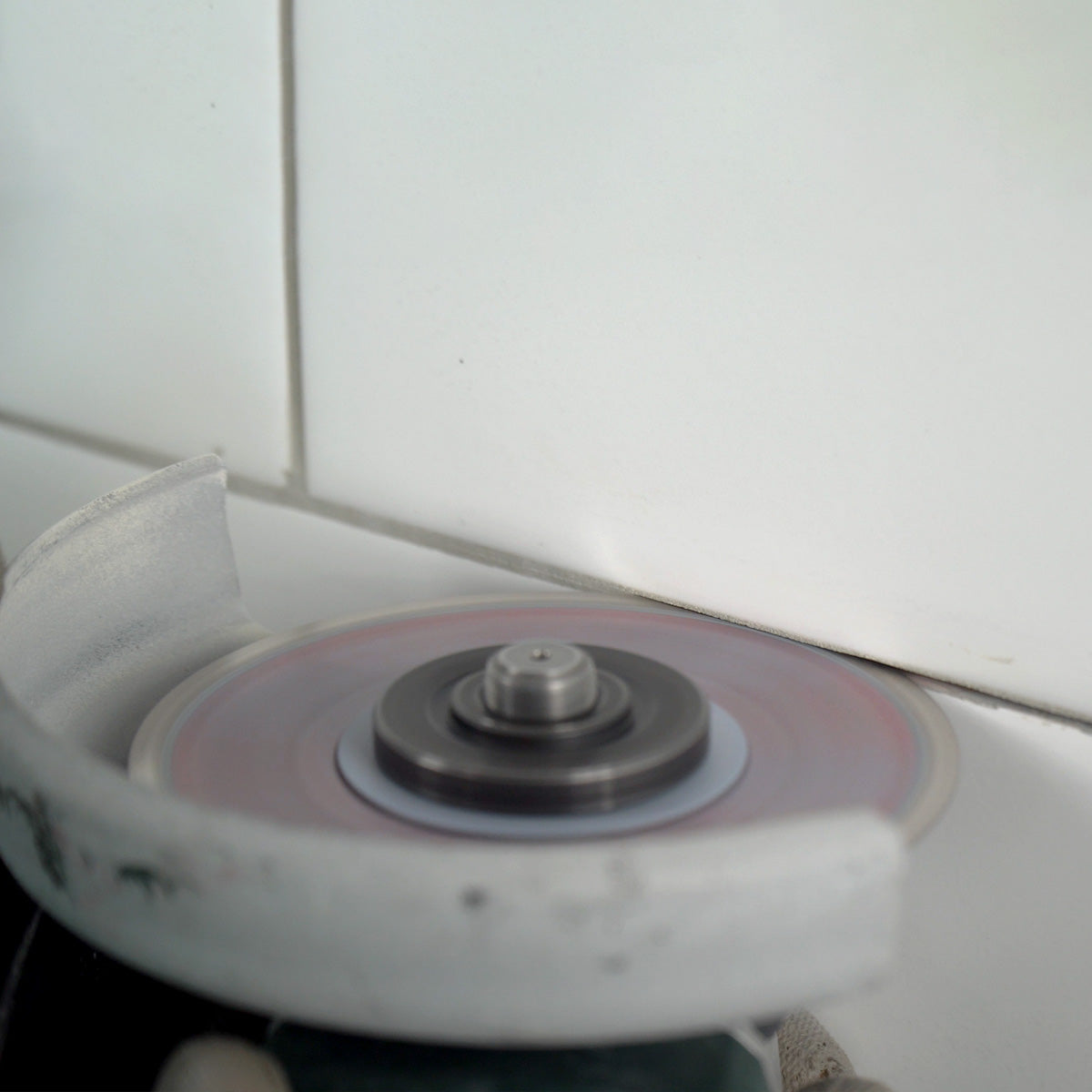 Worker using Cleaner 4 inch diamond blade on angle grinder to clean grout